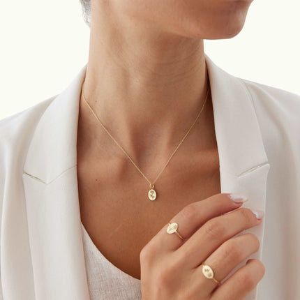 a woman wearing a white shirt and a gold necklace