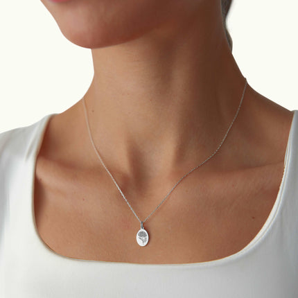 a woman wearing a necklace with a disc on it