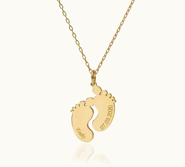 a gold necklace with a baby's footprints on it