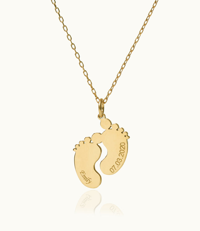 a gold necklace with a baby's footprints on it